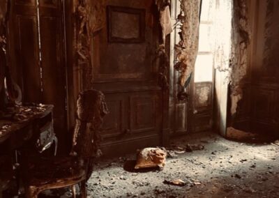 Habitación quemada con paredes ennegrecidas, cortinas calcinadas y escombros en el suelo