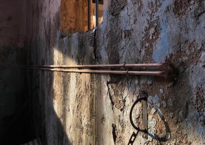 Muro desconchado con una cadena de hierro anclada
