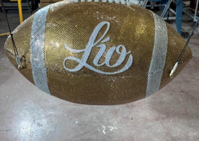 Balón gigante de pedrería dorada con el logotipo de Lío, en el taller