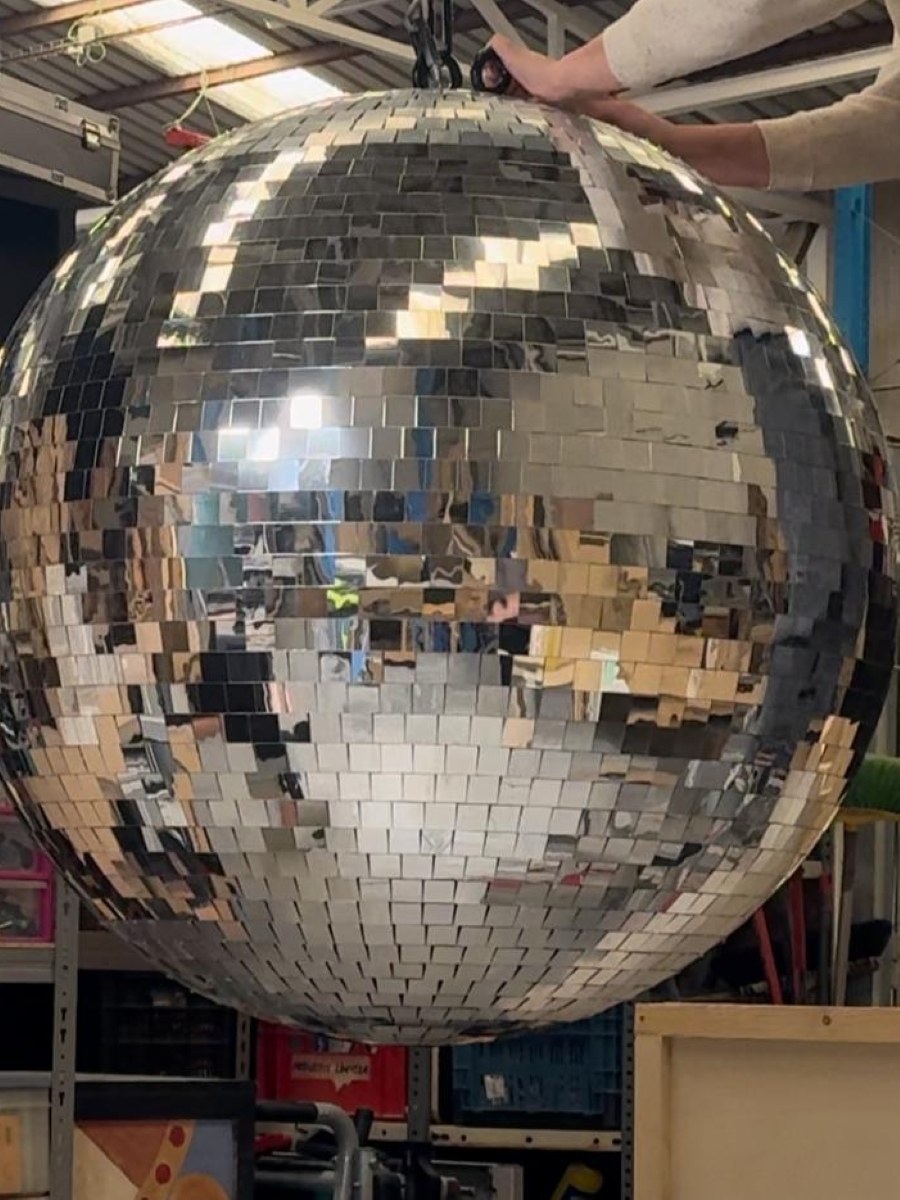 Bola de discoteca gigante colgada en el taller