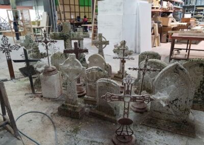 Lápidas y cruces de hierro ficticias reunidas en el taller