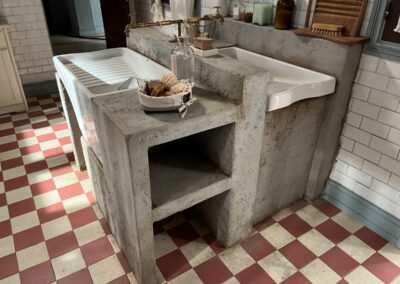 Lavadero de hormigón con dos pilas y estantes, en un decorado de cocina