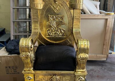 Trono egipcio dorado con asiento negro, en el taller