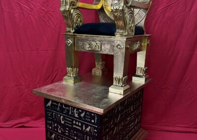 Trono egipcio dorado sobre su base con jeroglíficos