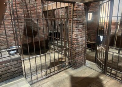 Rejas de hierro de las celdas de ladrillo, con una puerta abierta