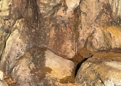 Pared de roca de la cueva con suelo de tierra