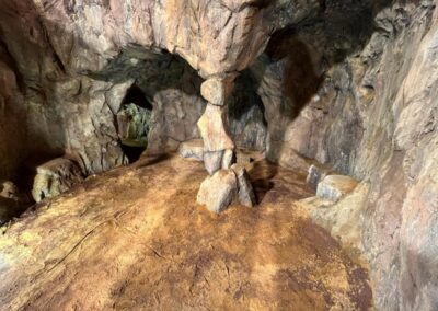 Interior de la cueva con una columna de roca y galerías al fondo