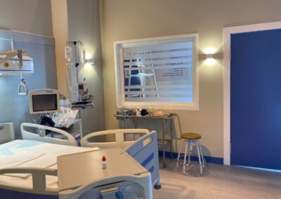 Habitación de hospital con dos camas y puerta azul