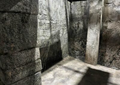 Pasadizo estrecho entre muros de piedra con un pilar en el centro