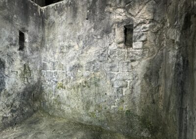 Muro de piedra con humedades y dos aberturas pequeñas