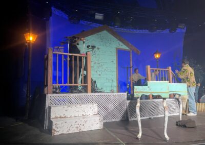 Porche de madera con barandilla y celosía blanca en el escenario