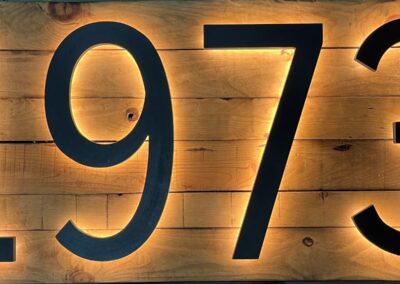 Detalle del logotipo luminoso 1973 sobre tablas de madera retroiluminadas