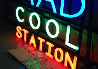 Rótulo luminoso Mad Cool Station encendido en el taller