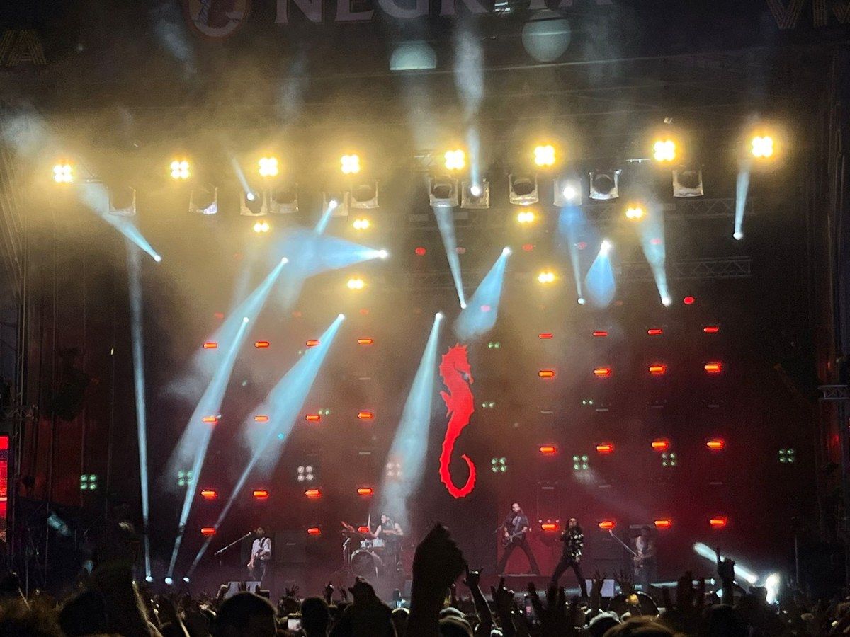 Concierto de Arde Bogotá con focos y el caballito de mar en rojo al fondo