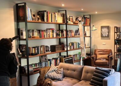 Librería de estantes de madera llena de libros en el decorado de la película «El ser querido»
