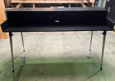 Soporte de teclado negro con patas metálicas finas, vista frontal
